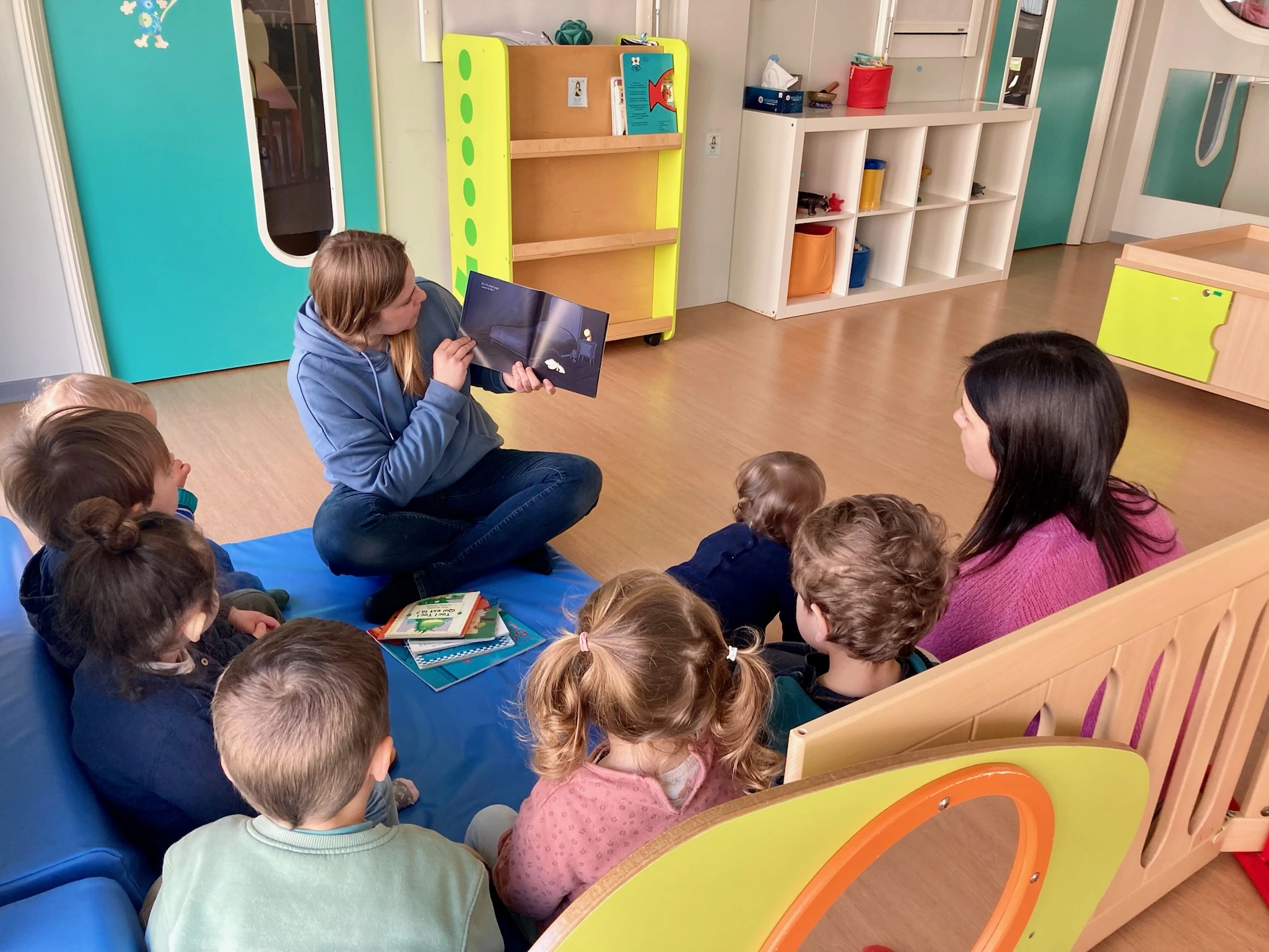 Personne montrant un livre à des enfants